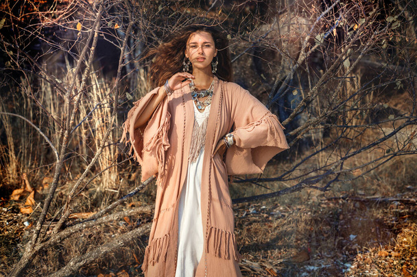 beautiful young stylish woman on dry tree branch background - Valokuva, kuva