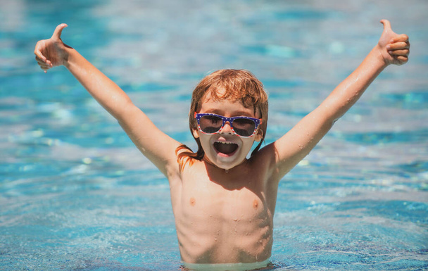 Мальчик плавает в бассейне. Спорт и отдых Ребенок у бассейна, дети плавают и играют в воде, дети счастья и летом. - Фото, изображение