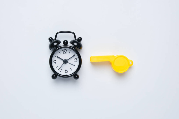 A picture of alarm clock and whistle on white background. Extra time concept - Photo, Image