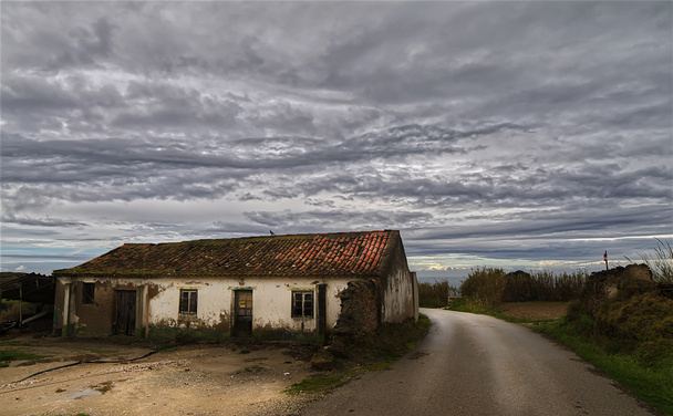 Una vecchia casa abbandonata con un cielo drammatico - Foto, immagini