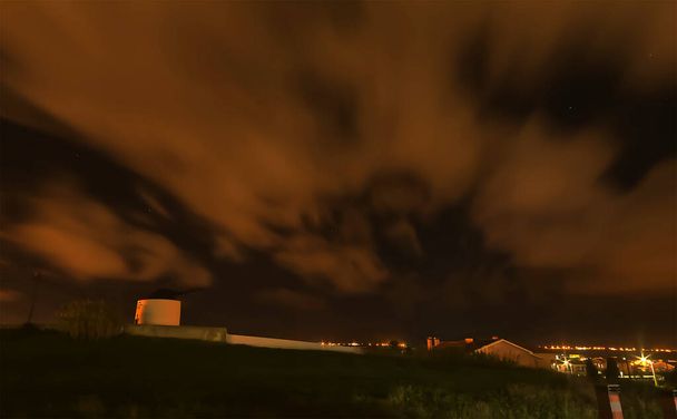Νυχτερινό τοπίο με συννεφιασμένο ουρανό και ένα παλιό ανεμόμυλο - Φωτογραφία, εικόνα