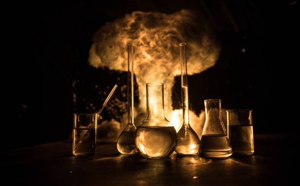 Pharmacy and chemistry theme. Test glass flask with solution in research laboratory. Science and medical background. Laboratory test tubes on abstract explosion cloud background. Selective focus - Fotó, kép