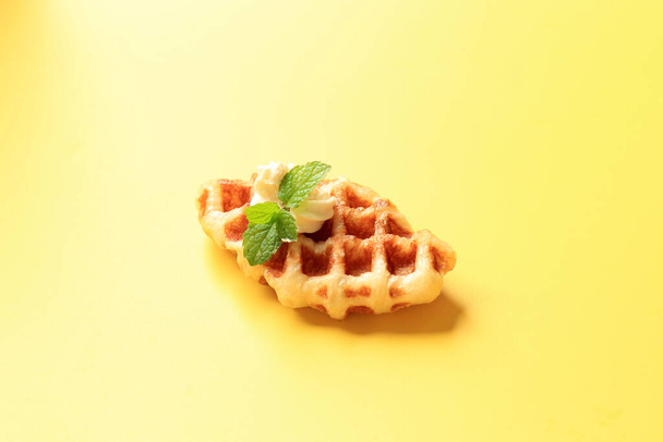 Close Up Croissant Waffle (Croffle) con queso crema en la parte superior aislado sobre fondo amarillo - Foto, imagen