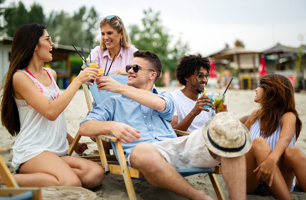 Group of young friends having fun at the beach on a sunny day. People vacation happiness drink concept. - Fotoğraf, Görsel
