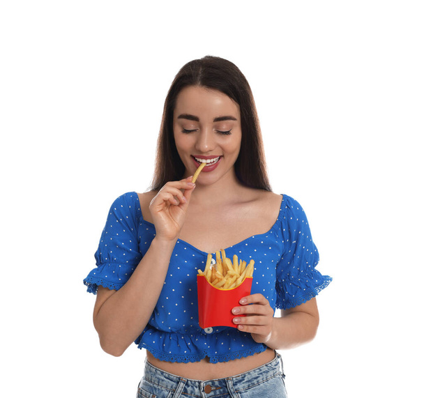 Beautiful young woman eating French fries on white background - Fotoğraf, Görsel