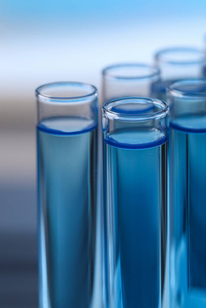 Test tubes with reagents on blurred background, closeup. Laboratory analysis - Zdjęcie, obraz