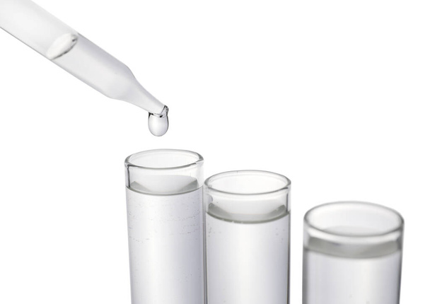 Dripping transparent liquid into test tube on white background, closeup - Фото, зображення