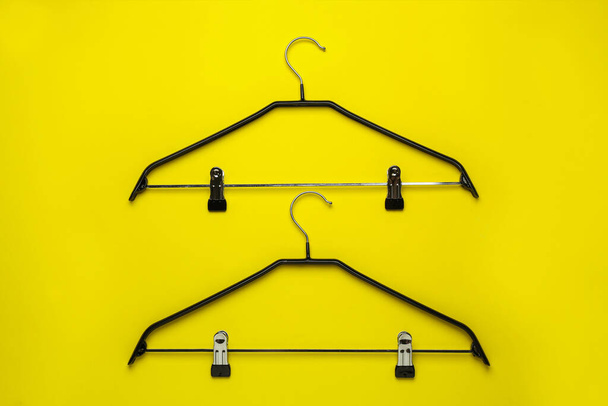Empty hangers with clips on yellow background, flat lay - Valokuva, kuva