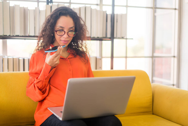 latin woman working with laptop on sofa at home - Photo, image