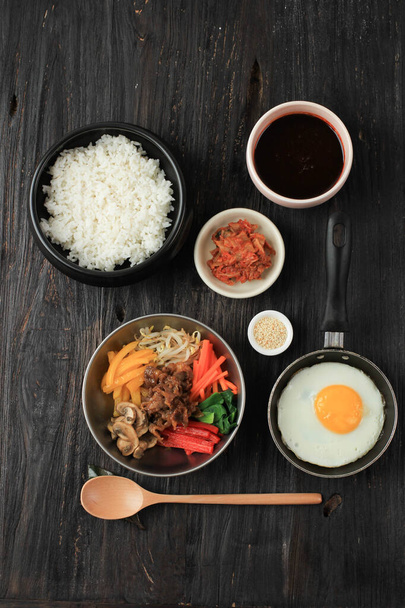 Bibimbap Rice with Mix Sautee Vegetables, Beef,  and Egg. Served with Red Spicy Bibimbap Sauce and Sesame Oil, Flat Lay Food Knolling Ingredients - 写真・画像