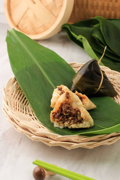 Zongzi o Bakcang. Dumplings de arroz pegajosos salados chinos envueltos con hojas de bambú  - Foto, Imagen