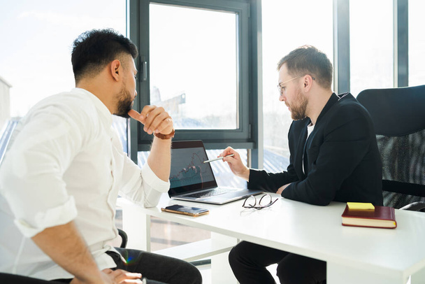 Dois empresários analisam o crescimento da empresa sentada no laptop no escritório - Foto, Imagem