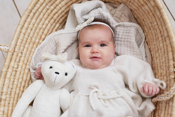 Söpö vauva tyttö neulotut vaatteet ja seppele nallekarhu lelu. Lastensuojelupäivä. Äitienpäivän onnittelukortti. Kansainvälinen onnellisuuden päivä. - Valokuva, kuva