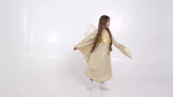 Kislány angyal szárnyakkal körözött a fehér háttér - Felvétel, videó