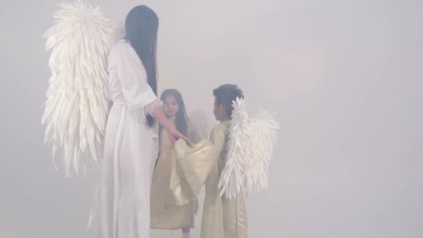 Rodina je oblečená ve svatých andělech, jsou v kouři a krouží  - Záběry, video