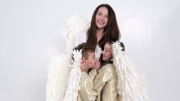 Šťastná rodina s bílými andělskými křídly na bílém pozadí, jsou šťastní  - Záběry, video