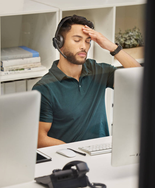 El trabajo de un agente del centro de llamadas es complejo y exigente. Fotografía de un hombre de negocios que parece estresado mientras trabaja en un centro de llamadas. - Foto, Imagen