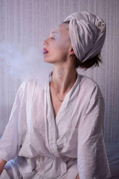 mulher atraente vaping e soprando fumaça, isolado em branco
 - Foto, Imagem