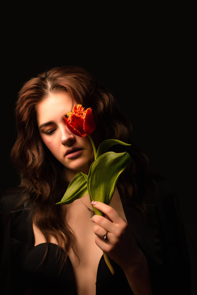 girl with a bouquet of tulips on black background. International Women's Day. Valentine's Day - Fotó, kép