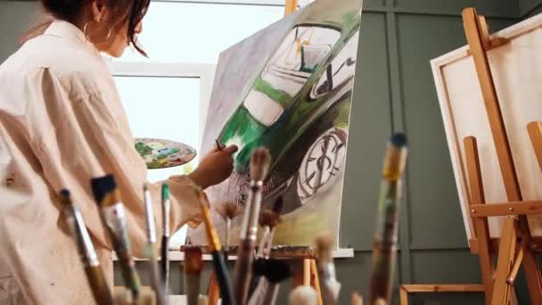 Estudio de arte - mujer artista dibujando un coche en el lienzo - Metraje, vídeo