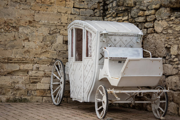 Vintage wagon in the old fortress. Vintage wagon in white. White cart. - Photo, Image