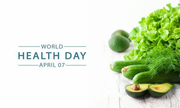 Wereldgezondheidsdag, elk jaar op 7 april. Verse en gezonde groenten achtergrond. Gezond voedingsconcept. Mix van groene groenten op witte tafel. - Foto, afbeelding