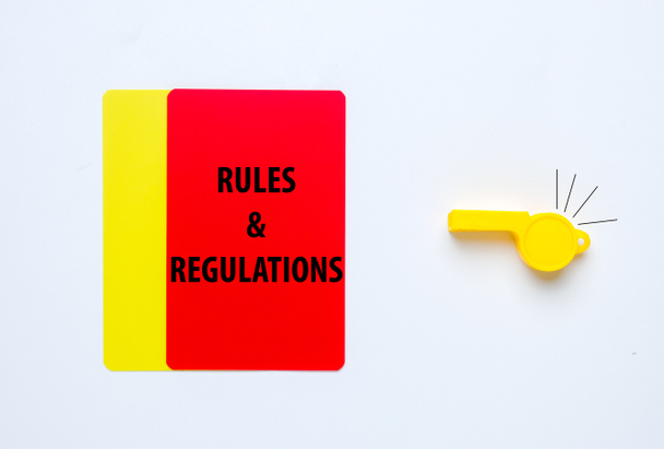 A picture of rules and regulations word on red and yellow card with whistle insight. Rules and regulations concept. - Valokuva, kuva