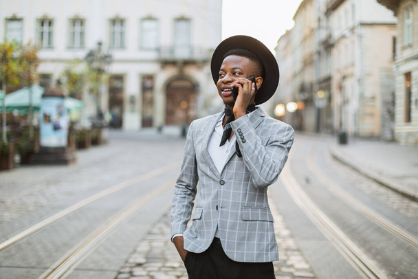 Stylish african man talking on mobile on city street - Φωτογραφία, εικόνα