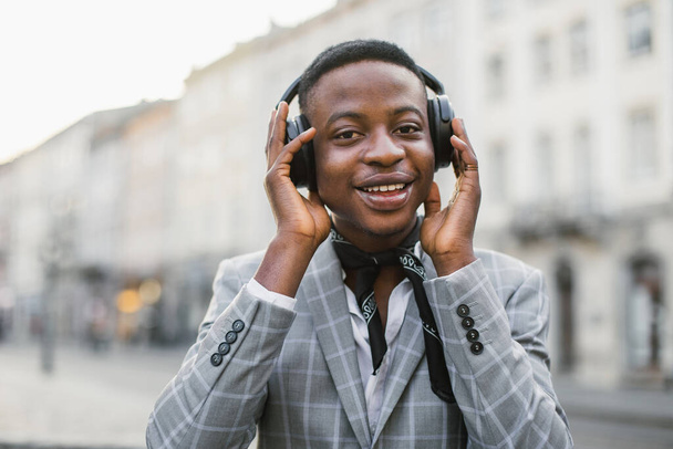 Happy african man in headphones listening music on street - Foto, Imagem