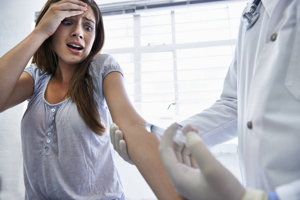 This wont hurt a bit. A doctor giving a woman an injection. - Zdjęcie, obraz