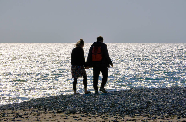 イタリア、シチリア島、プラヤグランデ(ラグーザ州);ビーチを歩くカップル - 写真・画像