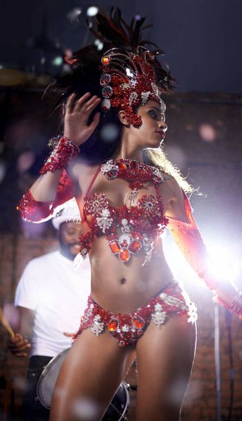 Encantador en rojo. Foto de una hermosa bailarina de samba actuando en un carnaval con su banda. - Foto, Imagen