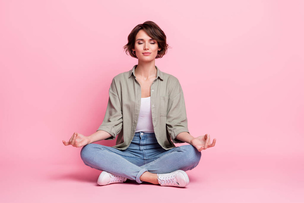 Foto de cuerpo completo de la señora bastante enfocada sentarse posición de loto meditar dedos mudra aislados sobre fondo de color pastel - Foto, imagen