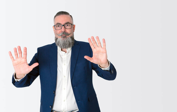 stylishly dressed bearded hipster in blue jacket on white background and copy space, raising hands and showing palms, - Photo, Image