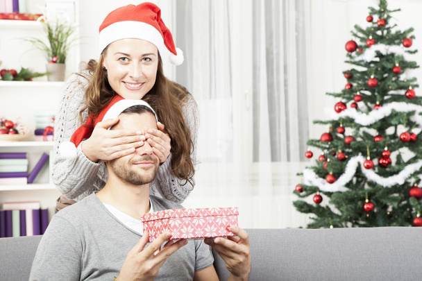 girls makes her boyfriend a christmas gift - Фото, изображение