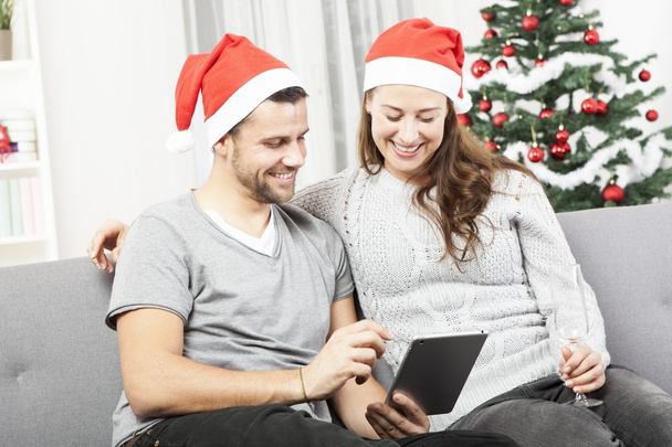 happy couple look on tablet pc for christmas - Zdjęcie, obraz