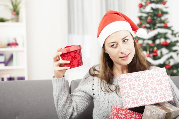 Chica joven sacudiendo regalo de Navidad
 - Foto, Imagen