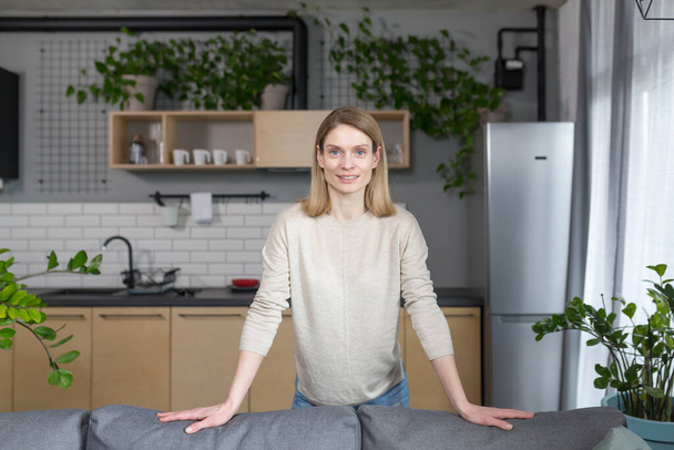 Portrait of a successful and happy woman at home, smiling and looking at the camera - Valokuva, kuva