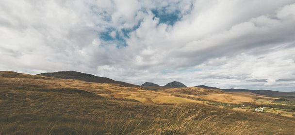 Góry wznoszą się pod ciemnym sztormem. Dramatyczne chmury. Wyspa Jura, Hebrydy Wewnętrzne, Szkocja, Wielka Brytania. Krajobraz atmosferyczny. Widok panoramiczny - Zdjęcie, obraz