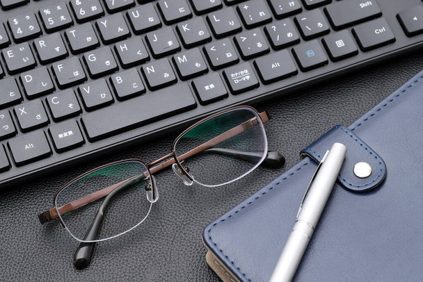 Óculos de visão com caderno de notas, teclado de computador. Alfabética e teclado de digitação hiragana japonês. - Foto, Imagem