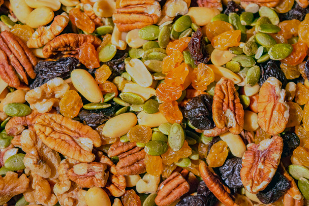 Un cuadro completo de frutos secos y frutos secos mezclados consiste en semillas de calabaza verde, cacahuetes pelados, pacanas, nueces, pasas de uva doradas y cerezas muertas, Ontario, Canadá. Fotografía de stock - Foto, imagen