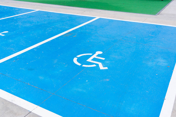 Exclusieve parkeergelegenheid in het blauw op de vloer geschilderd voor mensen met een rolstoel - Foto, afbeelding