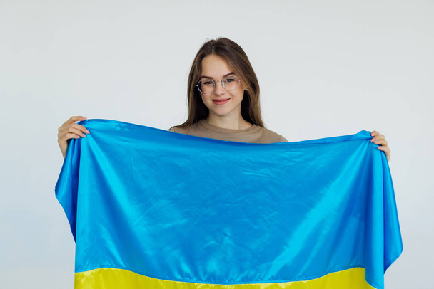 白い背景にウクライナのフラグを持つ美しい若い女性 - 写真・画像