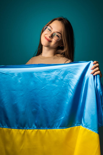 Nuori nainen Ukrainan lippu seisoo vihreä tausta. - Valokuva, kuva