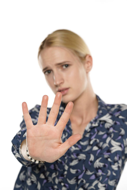 Young blond woman making stop hand sign on a white background - Photo, Image