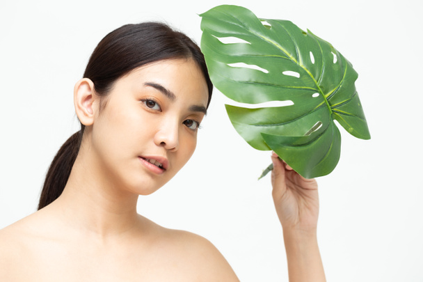 Junge asiatische Frau Schönheit mit natürlichen grünen Blatt isoliert auf weißem Hintergrund, Spa-Hautpflege und Schönheitsbehandlungskonzept - Foto, Bild