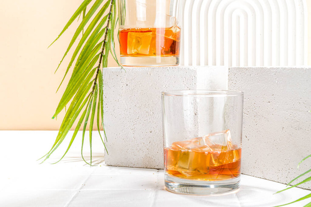 Bebida alcohólica, cóctel de alcohol fuerte frío de verano, whisky con hielo en vasos cortos sobre fondo blanco - Foto, Imagen