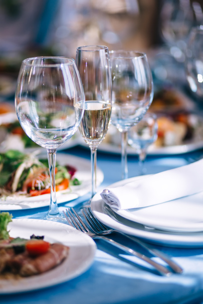 Tavolo da sposa decorato. Lussuosa tavola apparecchiata in un ristorante, bicchieri per champagne e vino. - Foto, immagini
