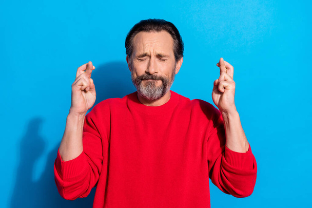 Portrait of funky stressed closed eyes mature man praying crossed fingers wish luck isolated on blue color background - Valokuva, kuva