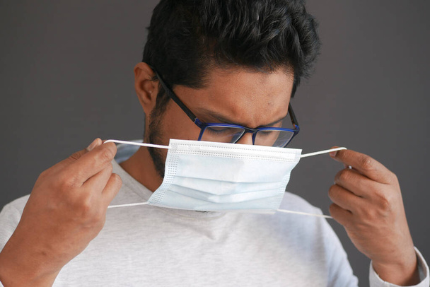 fiatal ázsiai férfi üzembe sebészeti arc maszk beltéri  - Fotó, kép